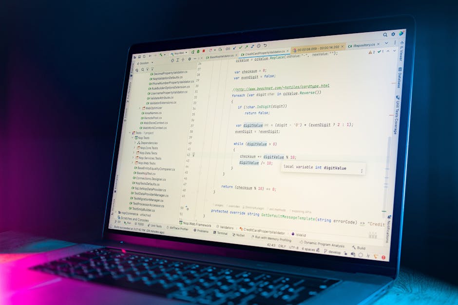 A close-up of a laptop screen displaying lines of computer code in a programming language, with a visible keyboard at the bottom. The background is dark, with a subtle glow from the screen illuminatin